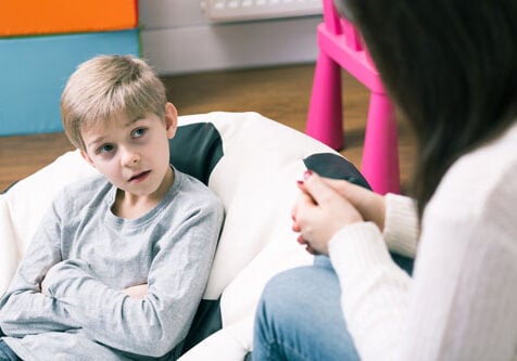 JFS Child Counseling. A counselor talks with a young boy during a session.